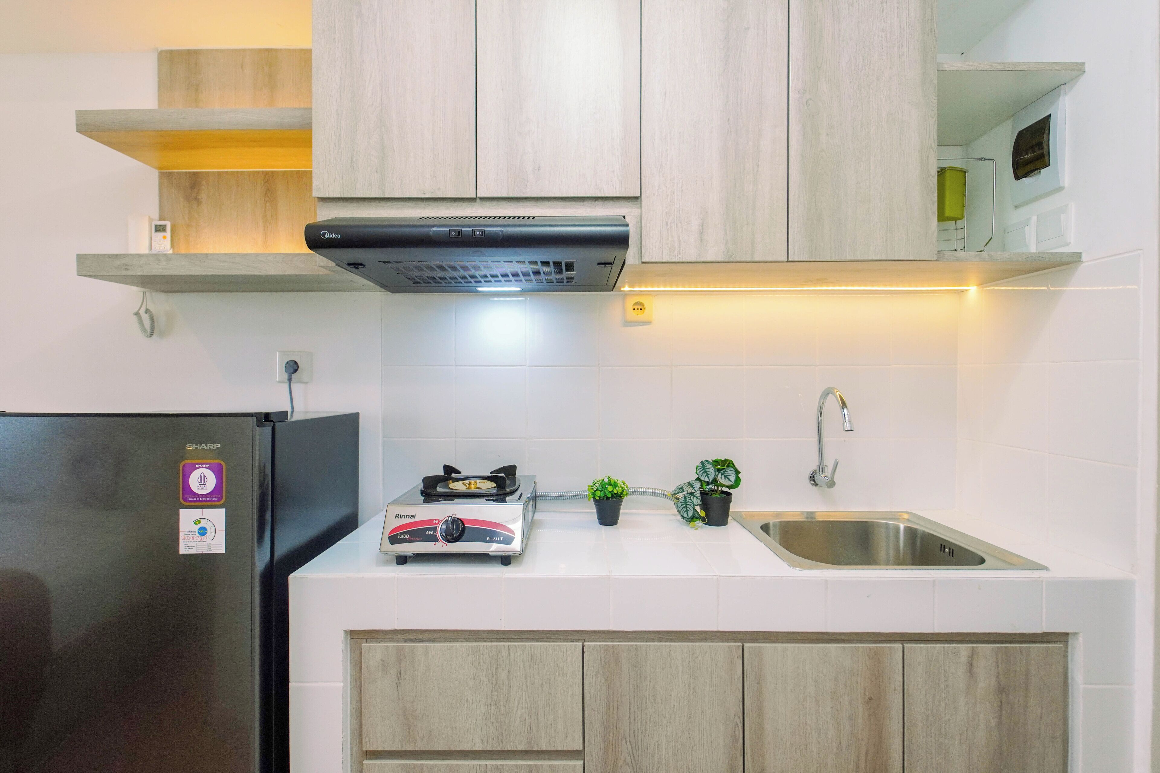 A modern kitchen with a built-in gas stove, a stainless steel sink, and wooden cabinets.