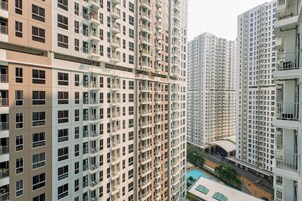 Un edificio residencial de gran altura con varios balcones y una zona de piscina.
