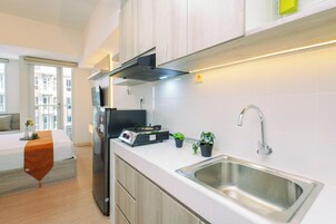Una cocina moderna con estufa integrada, un lavamanos y un ventanal con vistas a un paisaje urbano.