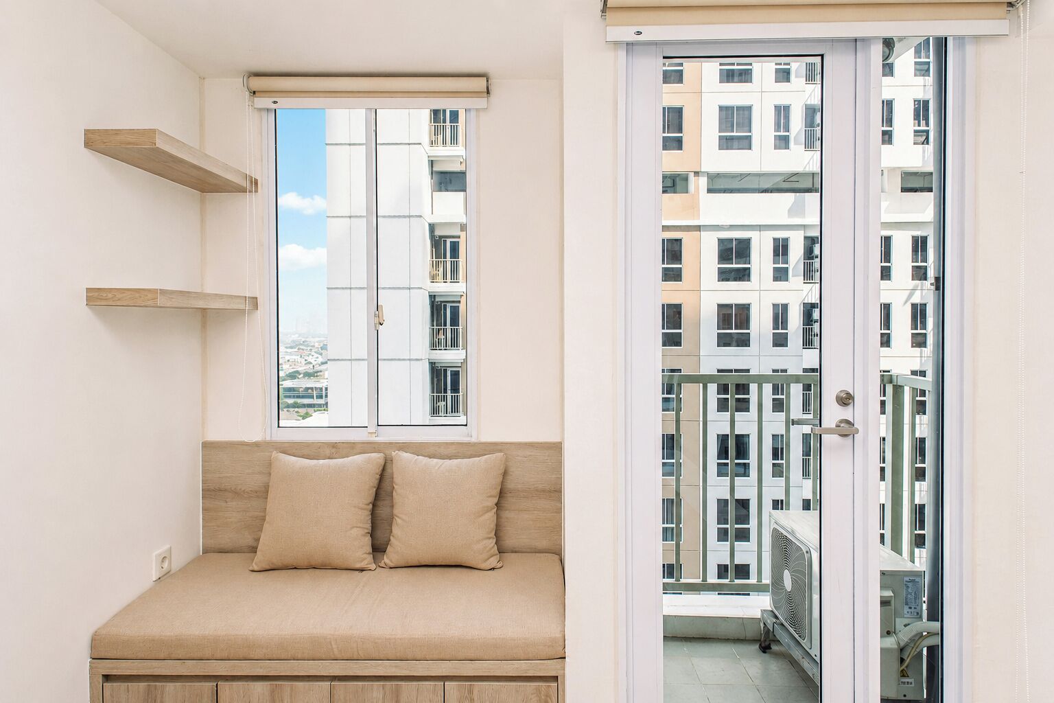 Een kamer met een bed, een raam en een deur naar een buitenbalkon.