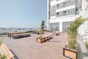 A rooftop terrace with outdoor seating and potted plants. - Stylish Bright 1Br At Apartment Kyo Society (Surabaya)