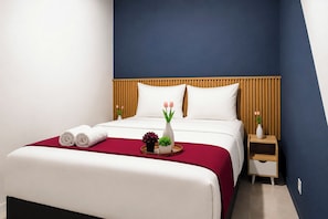 Een hotelkamer met een bed, een nachtkastje en een bedtafel.