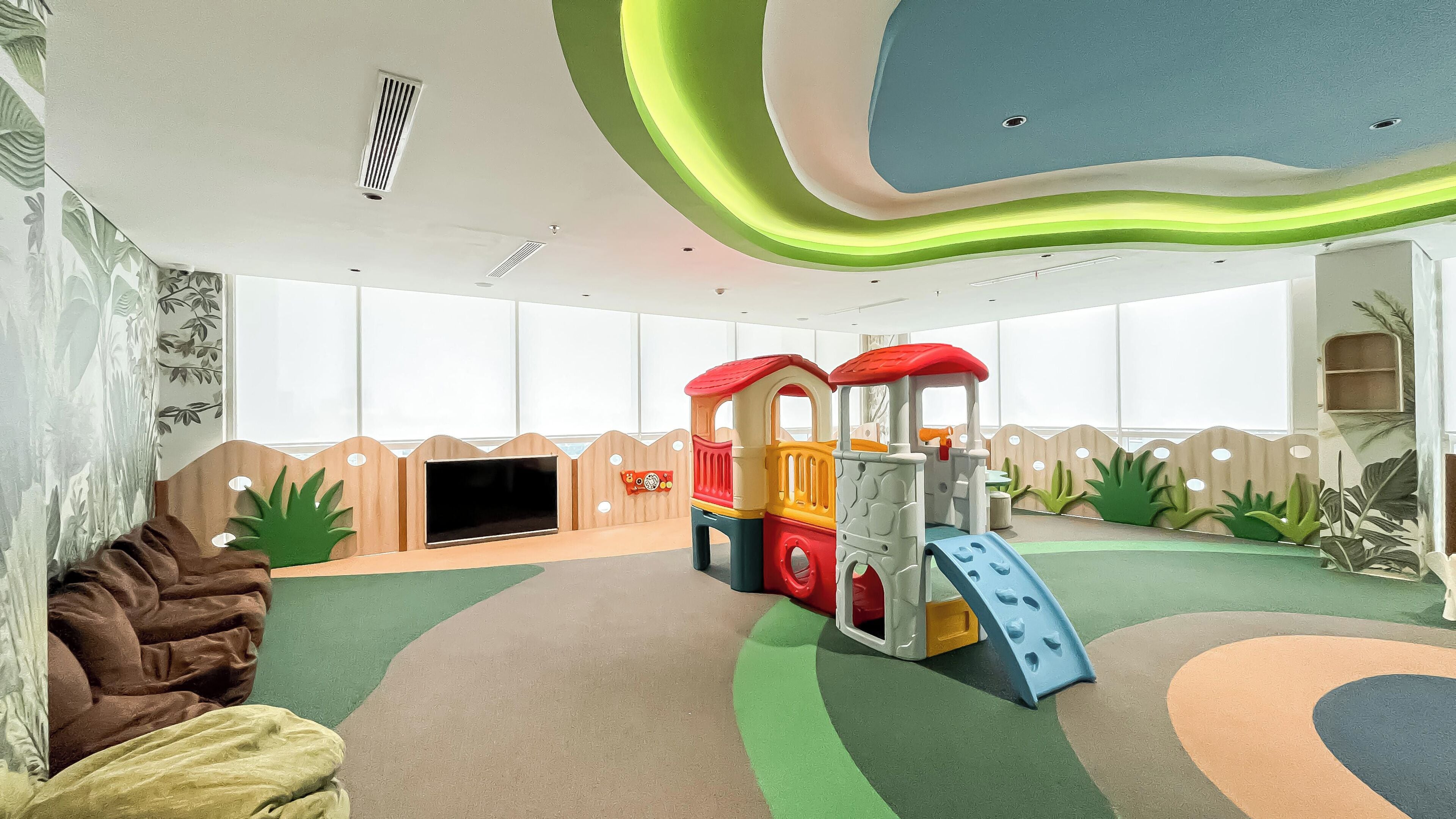 A play area with a slide and climbing structures, a sofa, and a television.