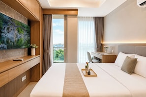 A modern hotel room with a bed, desk, and television. - Elegant Studio At Apartment Antasari Place (Jakarta)