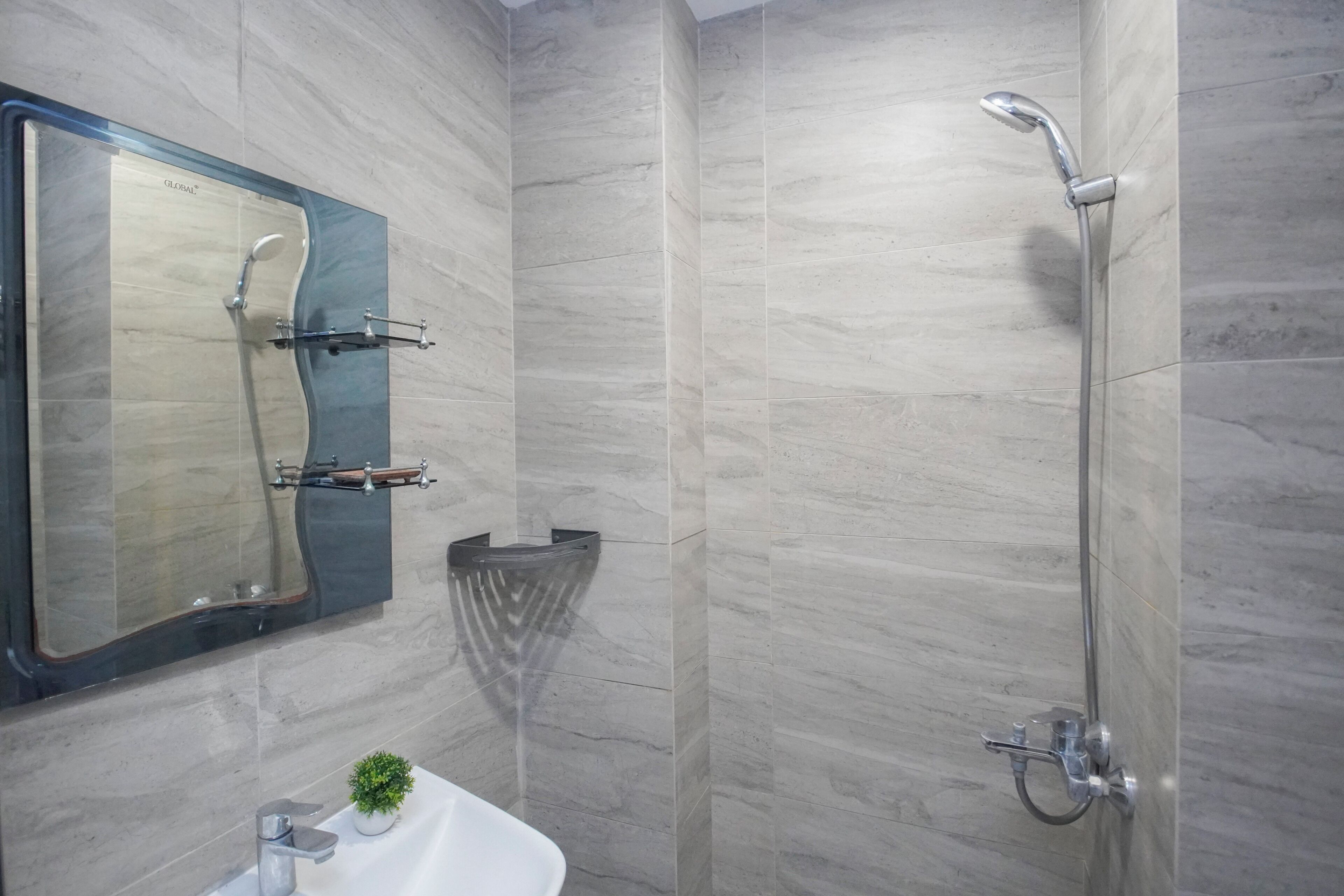 Un baño con ducha, lavabo y espejo.