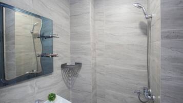 Un baño con ducha, lavabo y espejo.