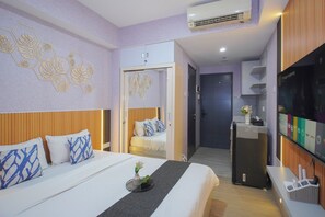 Ein Hotelzimmer mit Bett, Nachttisch und Fernseher.
