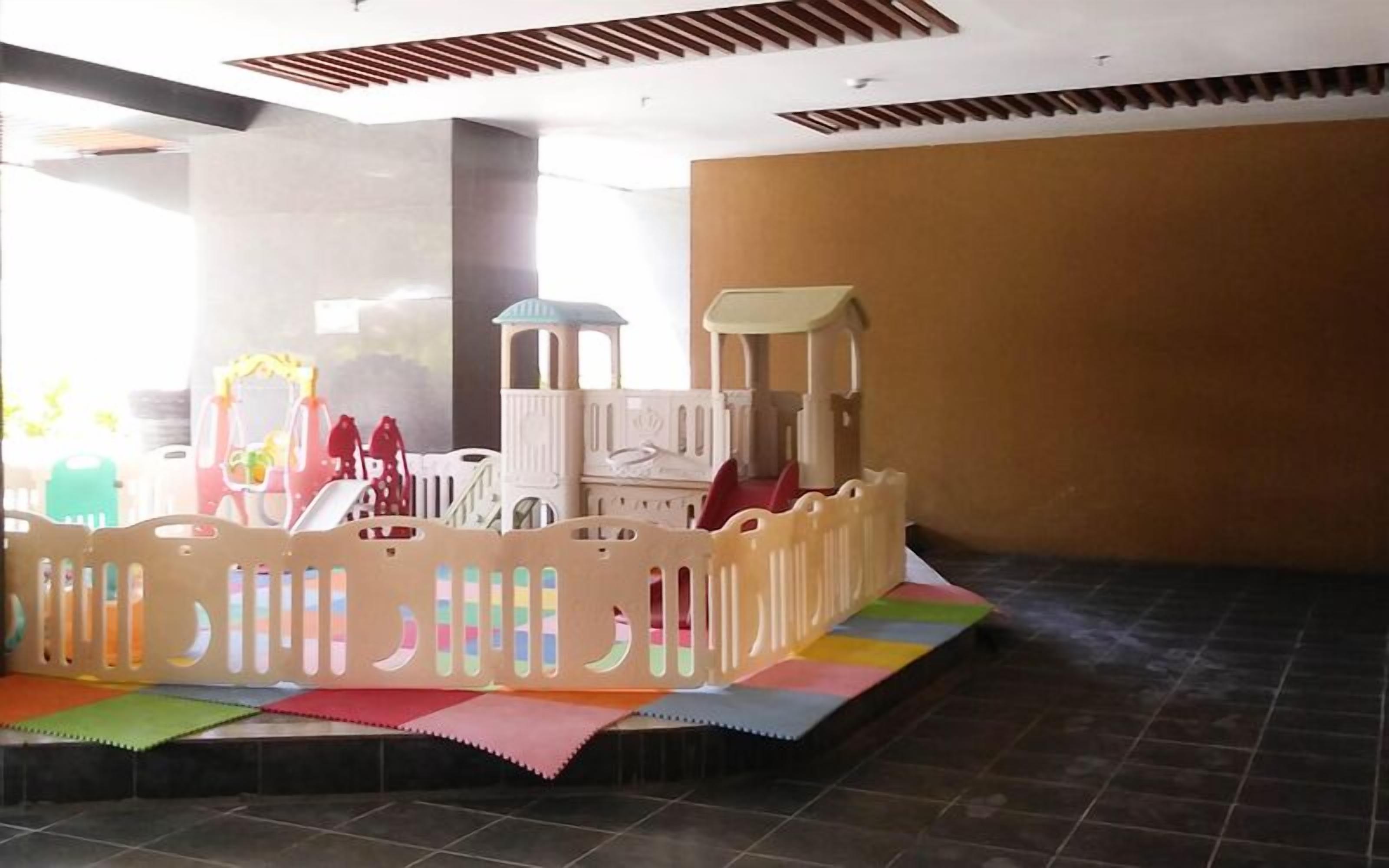 A play area with a soft play structure and colorful mats.