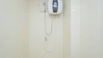 Una ducha con panel de control y cabezal de ducha manual, instalada en una pared con azulejos.