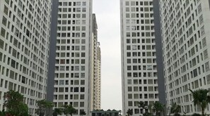 Un edificio de gran altura con fachada enrejada, varios pisos y un patio central con árboles.