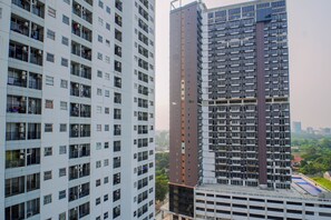 Ein Hochhaus mit mehreren Etagen, Balkonen und einer Mischung aus Wohn- und Gewerbeflächen.