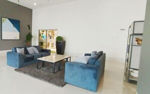 Ein modernes Wohnzimmer mit zwei Sofas, einem Couchtisch und einer großen Topfpflanze.
