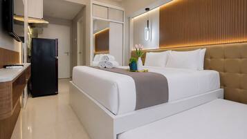 A modern hotel room with a bed, bedside table, and a built-in TV.