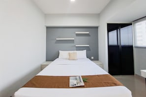 Un dormitorio moderno con cama, mesitas de noche y ventana con persianas.