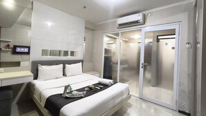 Ein modernes Hotelzimmer mit einem Bett, einem Flachbildfernseher, einem Kleiderschrank und einer Klimaanlage.