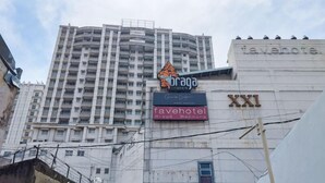 A building with multiple floors, a prominent 'tavernhotel' sign, and a 'farnotel' sign. - Best Deal 3Br Apartment Braga City Walk (Bandung)