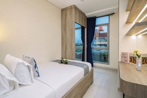 A modern bedroom with a bed, bedside tables, a window with curtains, and a view of buildings outside. - Smart Value 2Br At Apartment Pejaten Park Residence (Jakarta)