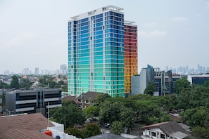 A multi-story building with a grid-like facade, surrounded by trees and other buildings. - Smart Value 2Br At Apartment Pejaten Park Residence (Jakarta)