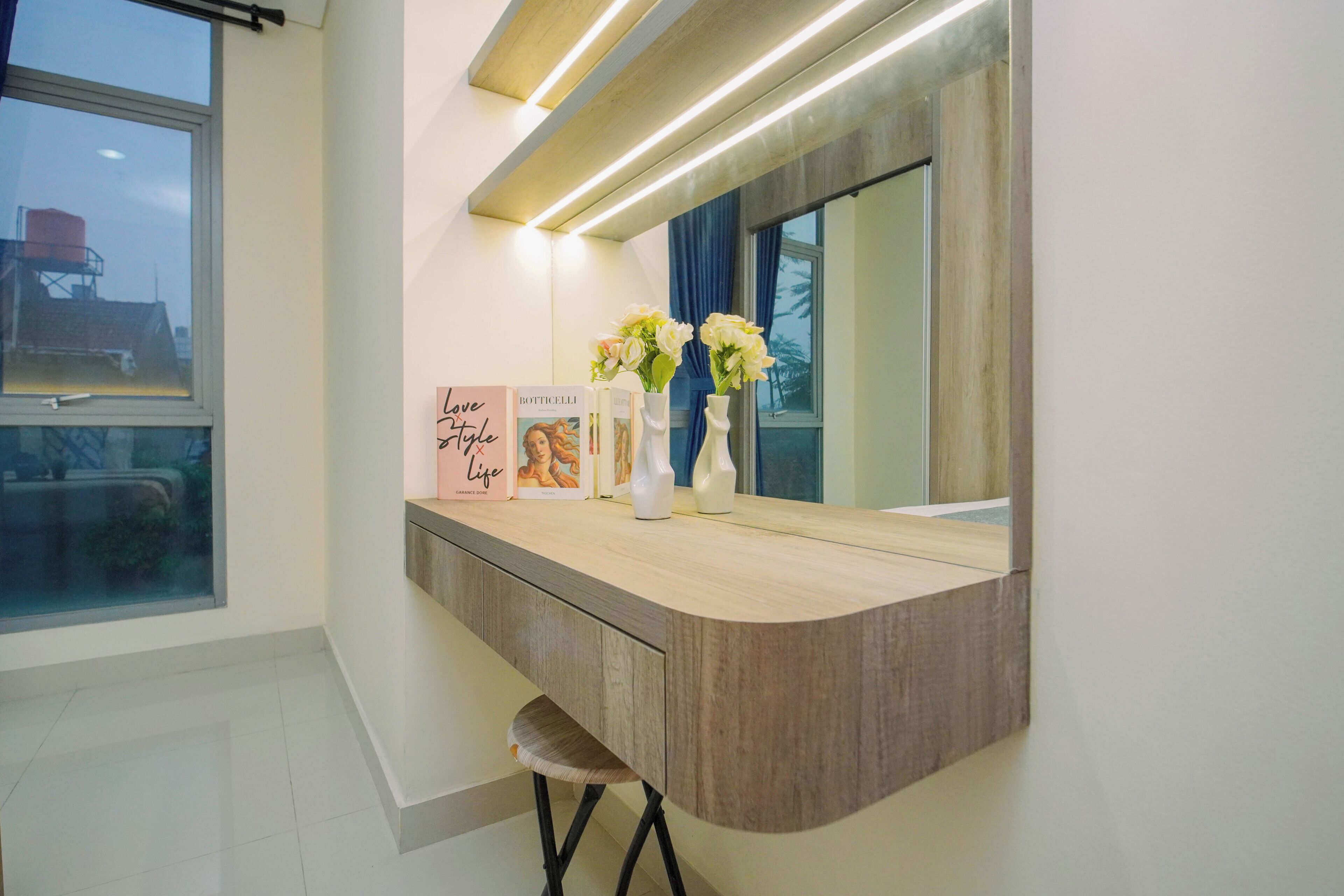 A modern bathroom with a vanity, a mirror, and a window.