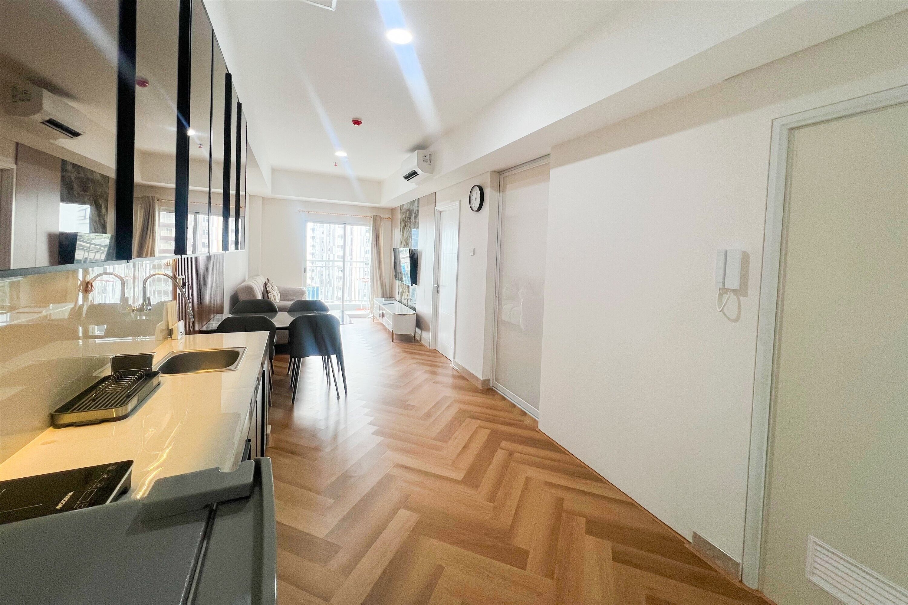Una cocina moderna con estufa integrada, comedor con sillas y un amplio ventanal que proporciona luz natural.
