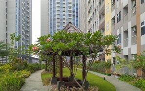 Un immeuble résidentiel doté d’un jardin agrémenté d’un belvédère.
