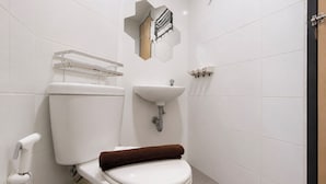 A modern bathroom with a toilet, sink, and towel rack. - Nice Look Studio Apartment at The Alton (Semarang)