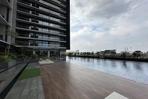 Een modern gebouw met meerdere balkons en een zwembad.