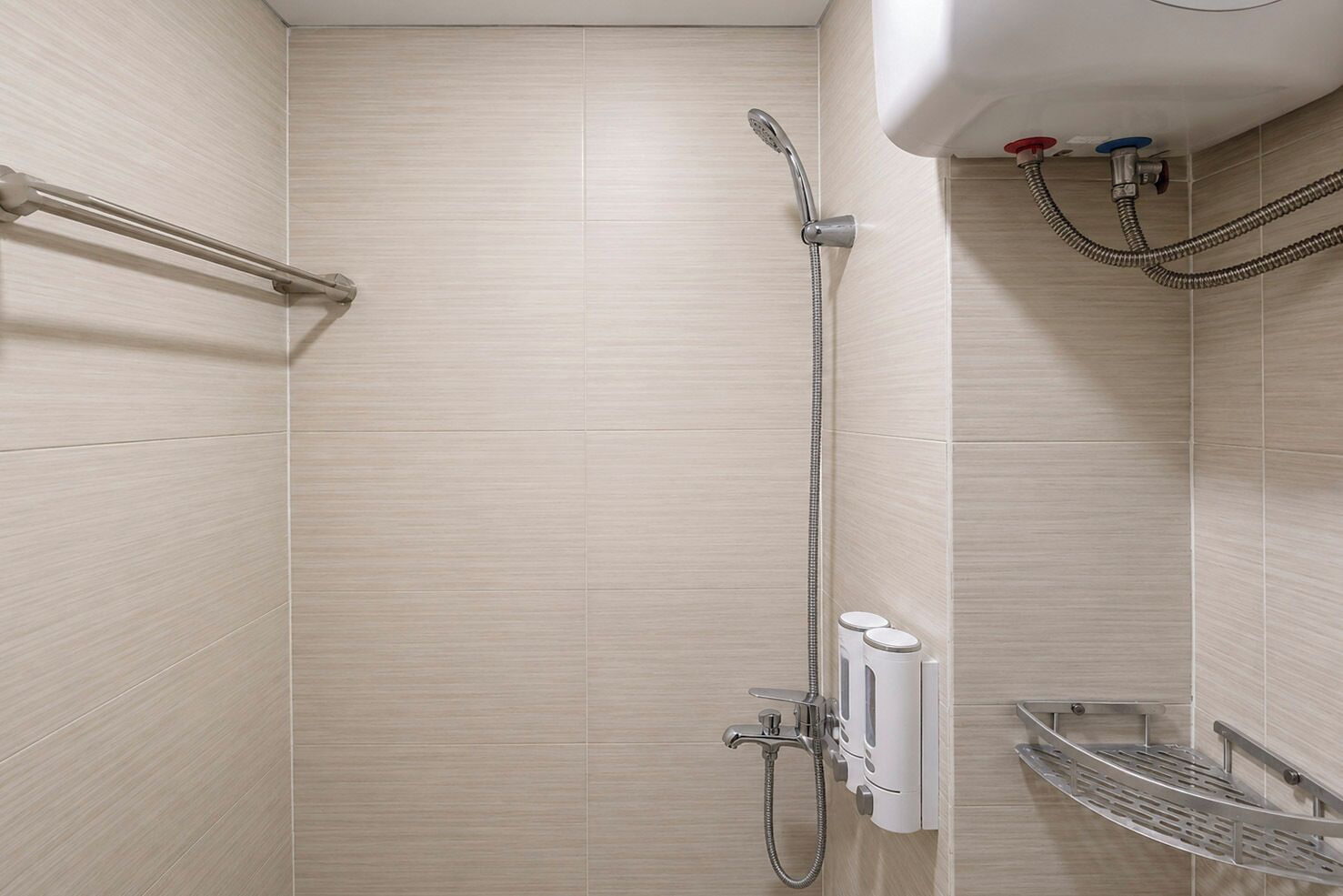 A shower area with a handheld showerhead, a wall-mounted faucet, and a metal shelf.