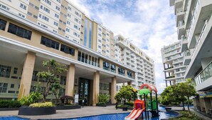 A residential building with a swimming pool and a children's play area. - Comfortable 2Br At Gateway Pasteur Apartment (Bandung)