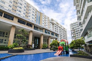 A residential building with a swimming pool and a children's play area. - Comfortable 2Br At Gateway Pasteur Apartment (Bandung)