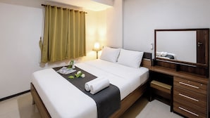 A hotel room with a bed, bedside table, lamp, and a mirror. - Comfortable 2Br At Gateway Pasteur Apartment (Bandung)