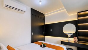 A modern hotel room with a bed, a bedside table, a mirror, and a wall-mounted air conditioning unit. - Airy And Modern 2Br At Apartment Teluk Intan (Jakarta)