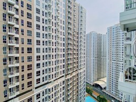 Un edificio residencial alto con varios balcones y una zona de piscina.