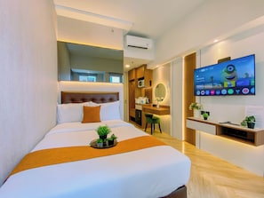 A hotel room with a bed, a desk, a television, and a mirror. - Enjoy Living Studio (No Kitchen) At Apartment Tokyo Riverside Pik 2 (Teluknaga)