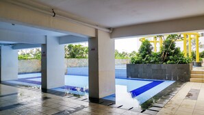 Un área de piscina cubierta con suelo de baldosas y pared de piedra.