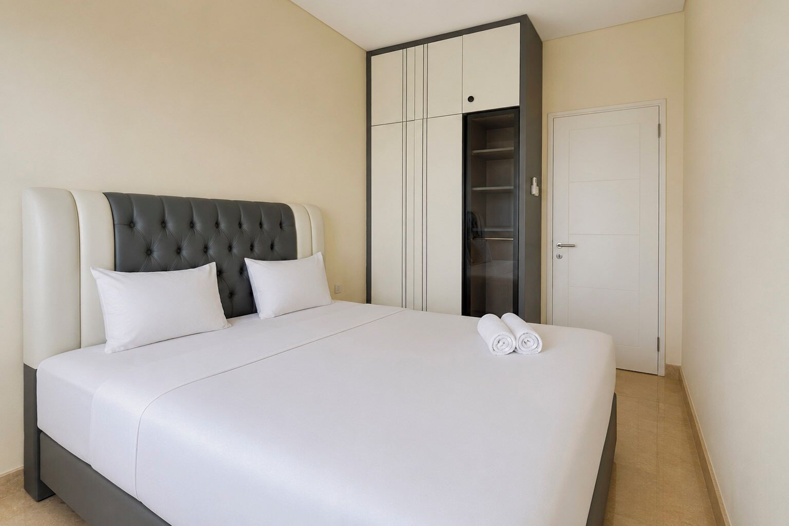 Una habitación de hotel con una cama grande, un armario y una puerta.