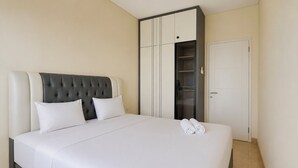 Ett hotellrum med en stor säng, en garderob och en dörr.
