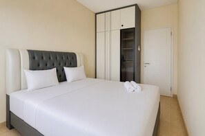 Ein Hotelzimmer mit einem großen Bett, einem Kleiderschrank und einer Tür.