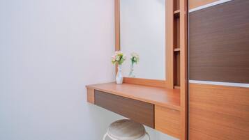 Un tocador moderno con espejo, mueble de madera y un taburete.
