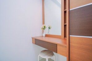 Un tocador moderno con espejo, mueble de madera y un taburete.