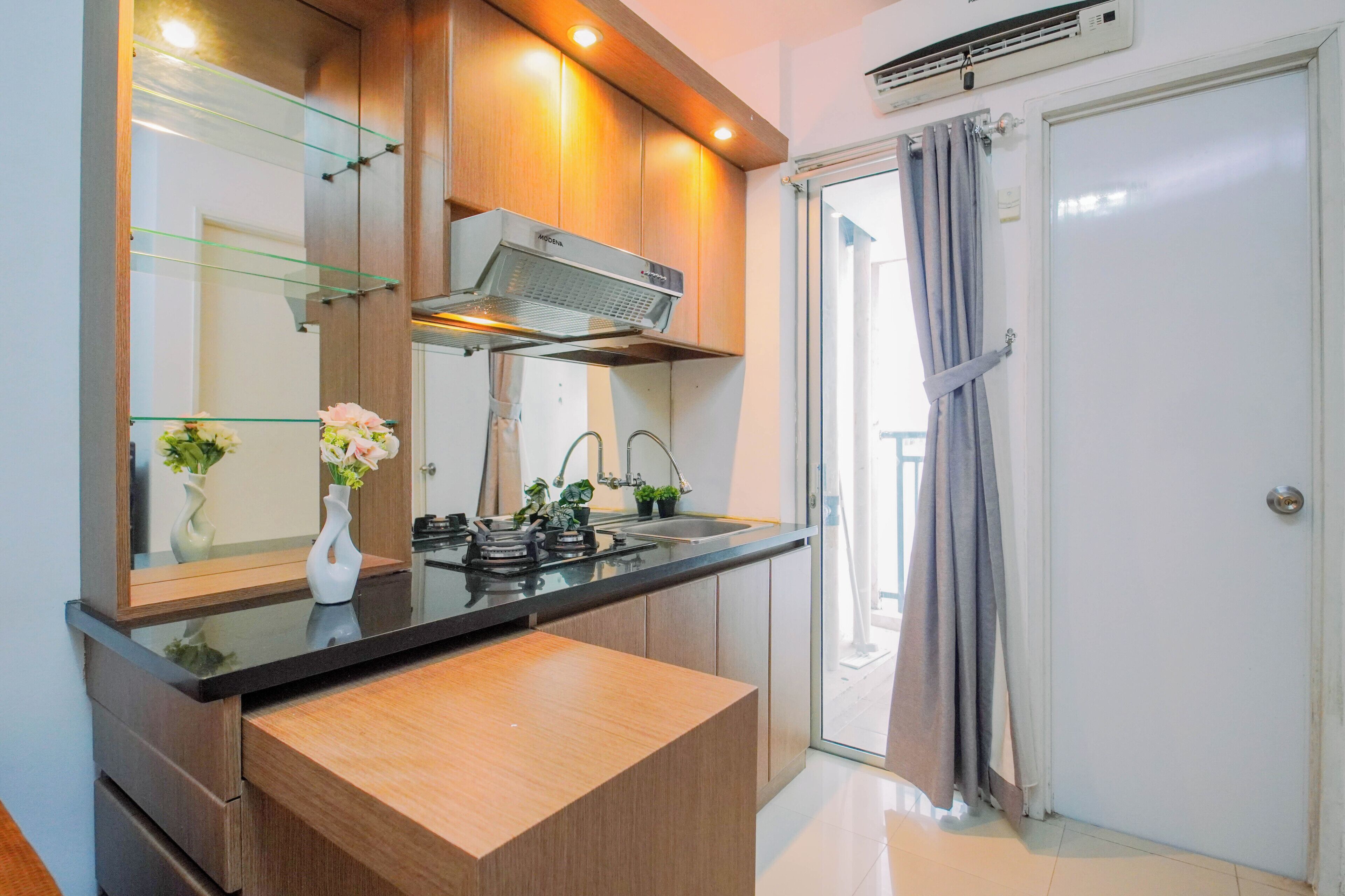 Uma cozinha moderna com fogão embutido, micro-ondas e armário com porta de vidro.