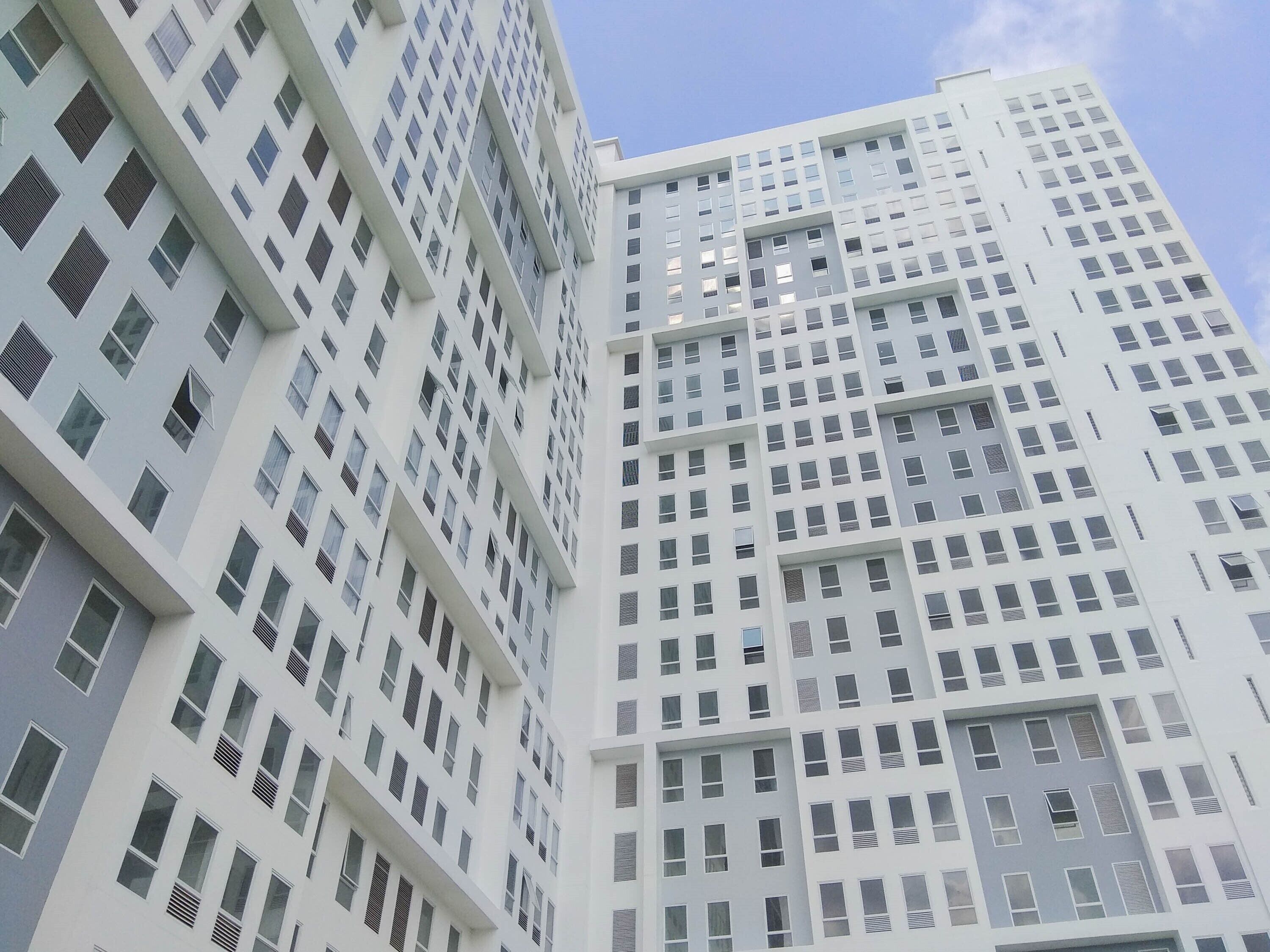 Un edificio alto con una fachada de ventanas y balcones.