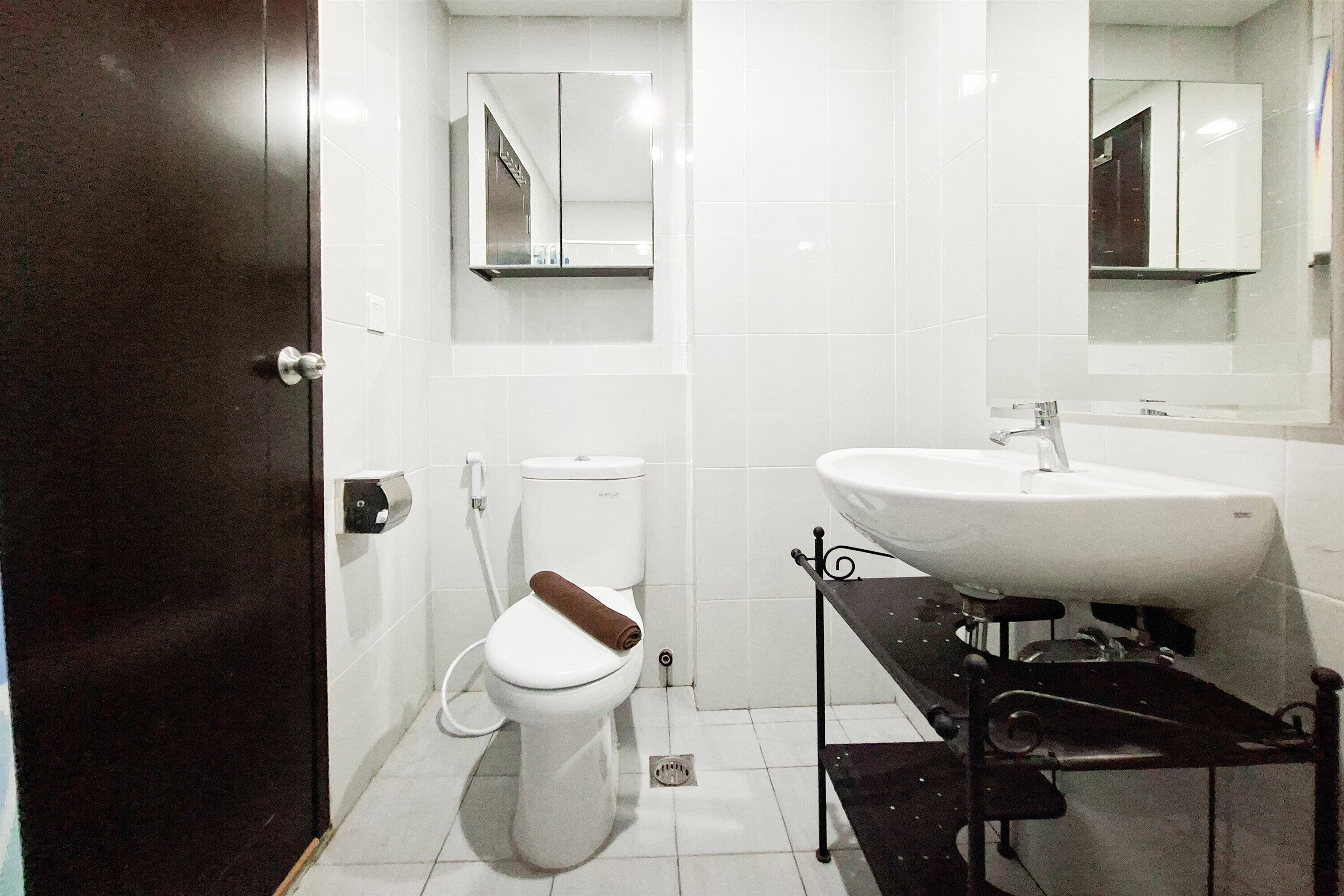 A bathroom with a toilet, a sink, and a mirror.