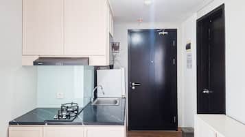 Una cocina funcional con estufa a gas, lavamanos y armarios.