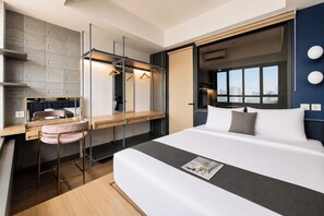 Ein modernes Hotelzimmer mit Bett, Schreibtisch, Stuhl, Spiegel und Fenster mit Blick auf die Stadt.