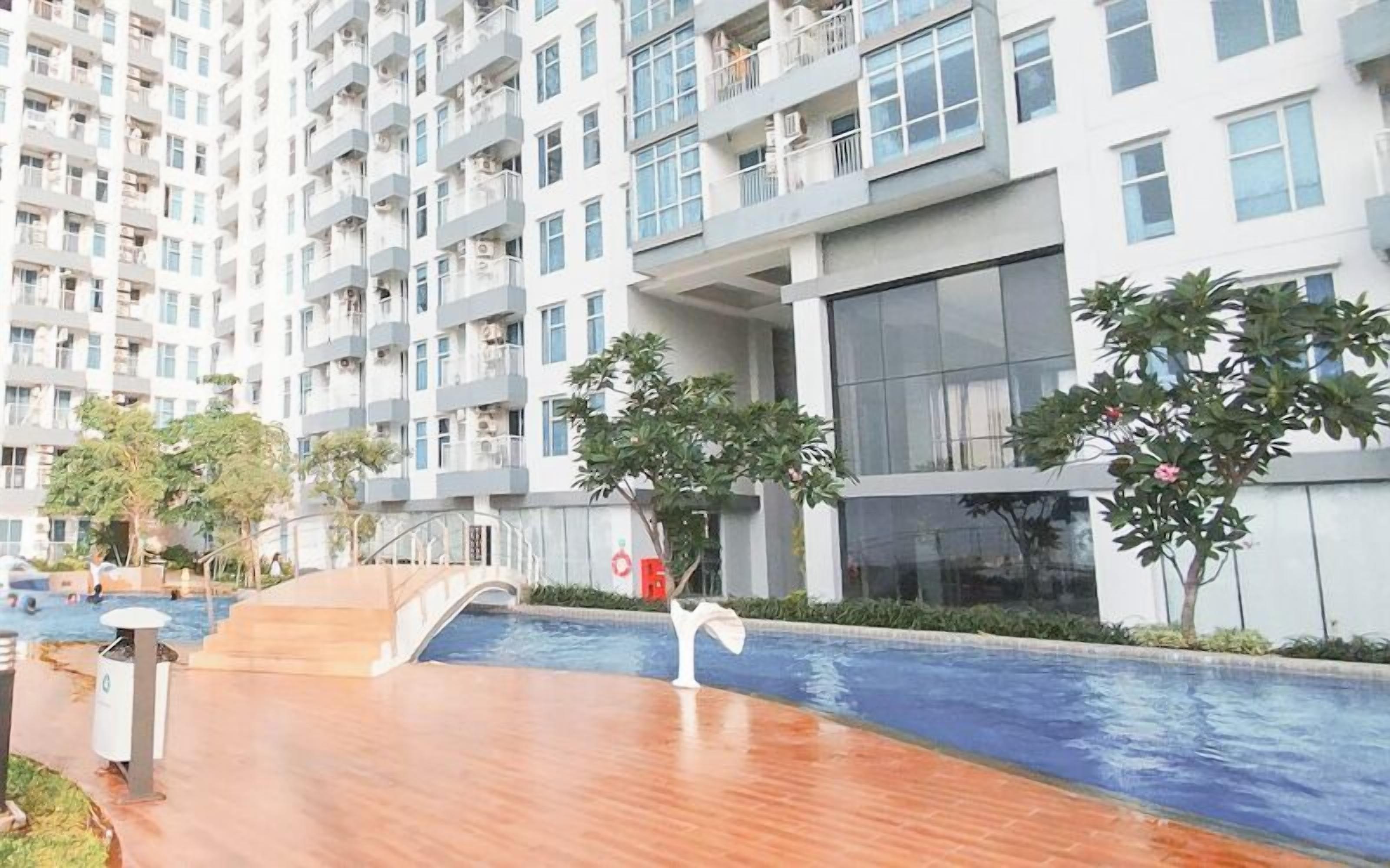 Un moderno edificio de apartamentos con piscina, mobiliario exterior y zonas verdes.