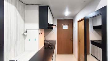 A compact kitchen with a stove, sink, and cabinets.