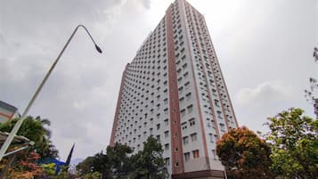 Um edifício alto, com vários andares, fachada uniforme e várias janelas.