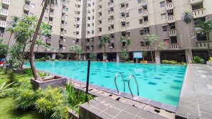 Un edificio residencial con varios balcones y una piscina.