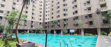 A residential building with multiple balconies and a swimming pool.